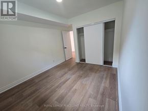 Toronto (University) apartment for rent - A room with wooden flooring and white walls, with a door on the right side.