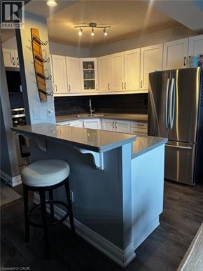 St. Catharines condo for rent - A kitchen with a bar stool in front of a counter.