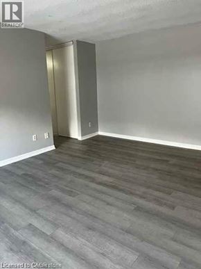 Waterloo condo for rent - A room with a wooden floor and a white wall.