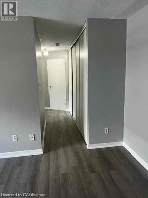Waterloo condo for rent - A hallway with wood flooring and white walls.