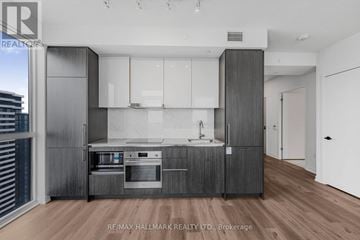 Vaughan (Vaughan Corporate Centre) condo for rent - A modern kitchen with white cabinets and a wooden floor.