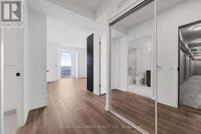 Vaughan (Vaughan Corporate Centre) condo for rent - A hallway with a black door and a mirror on the wall.