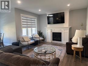 Belle River apartment for rent - A living room with a fireplace and a television mounted above it.