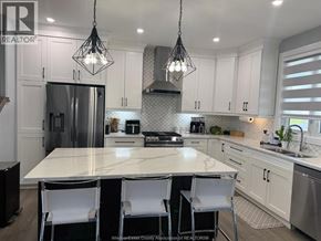 Belle River apartment for rent - A kitchen with white cabinets and a large island.