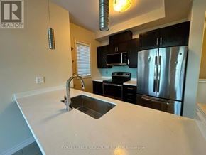 Hamilton (Stoney Creek Mountain) townhouse for rent - A kitchen with a sink and a refrigerator.