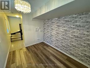 Hamilton (Stoney Creek Mountain) townhouse for rent - A room with a wooden floor and a brick wall.