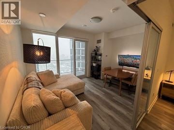 Kitchener condo for rent - A living room with a large couch and a painting on the wall.