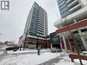 Kitchener condo for rent - A tall building with a glass facade stands next to a shorter building with a brick facade.