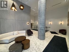 Kitchener condo for rent - A modern living room with a white couch, a brown ottoman, and a black and white rug.