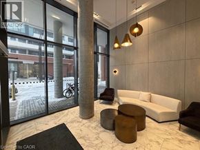 Kitchener condo for rent - A modern living room with a white sofa, a black coffee table, and a glass door leading to a balcony.