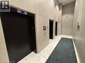 Kitchener condo for rent - A hallway with a black door and a blue light above it.