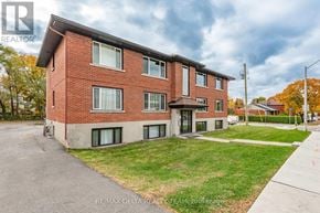 Ottawa multi-family for rent - A brick apartment building with a green lawn in front.