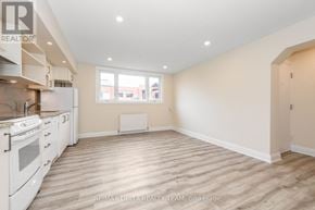 Ottawa multi-family for rent - A spacious kitchen with white appliances and wooden flooring.