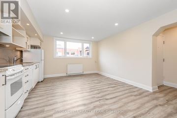Ottawa multi-family for rent - A spacious kitchen with white appliances and wooden flooring.