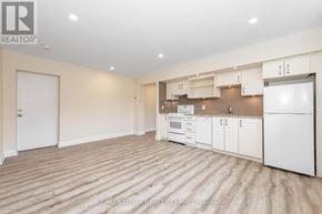 Ottawa multi-family for rent - A spacious kitchen with white appliances and cabinets.