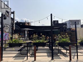 St. Catharines (Downtown) condo for rent - A patio area with tables and chairs and a bar in the background.