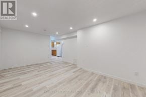 Barrie (Cundles East) apartment for rent - A spacious room with wooden flooring and white walls, with a doorway leading to another room.