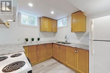 Barrie (Cundles East) apartment for rent - A kitchen with wooden cabinets and a white stove top oven.