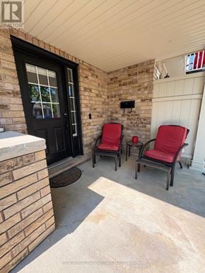 Milton (Co Coates) townhouse for rent - Two red chairs are on a porch with a black door.