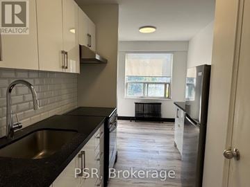 Toronto (Forest Hill North) condo for rent - A kitchen with black countertops and white cabinets.