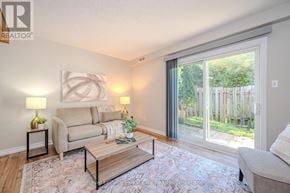 Guelph (Junction/Onward Willow) townhouse for rent - A living room with a couch, a coffee table, and a lamp.