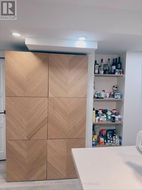 Newmarket (Bristol-London) apartment for rent - A wooden cabinet with a herringbone pattern is in the foreground of a room with a shelf stocked with bottles and containers in the background.