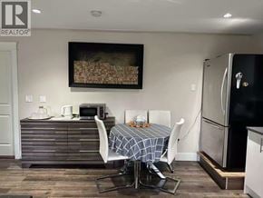 Coquitlam apartment for rent - A dining room with a table set for two and a fridge to the side.