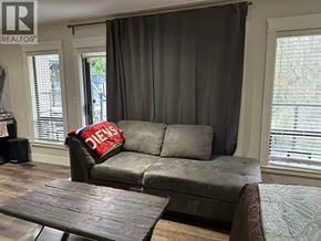 Coquitlam apartment for rent - A grey couch with a red pillow that says "JENS" on it sits in a living room.