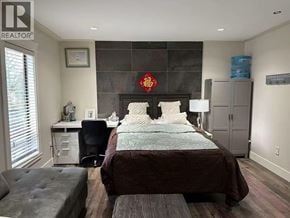 Coquitlam apartment for rent - A bedroom with a large bed and a desk with a computer.