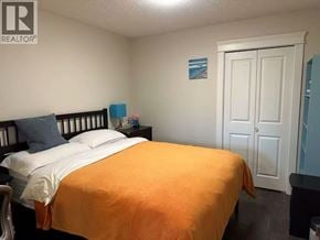 Coquitlam apartment for rent - A bedroom with a bed, nightstand, and a small painting on the wall.