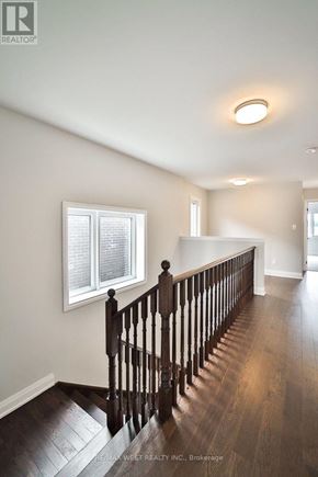 Springwater (Minesing) apartment for rent - A wooden staircase leads up to a brightly lit second floor.