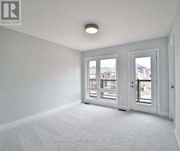 Springwater (Minesing) apartment for rent - A room with a carpet floor and a window with a view of buildings outside.