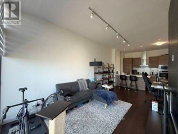 Toronto (Waterfront Communities) condo for rent - A living room with a grey couch and a bicycle.