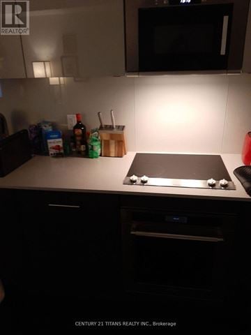 Toronto (Waterfront Communities) condo for rent - A kitchen with a stove top oven and a microwave above it.