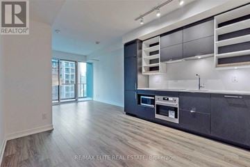 Toronto (Bay Street Corridor) condo for rent - A modern kitchen with dark wood cabinets and a stainless steel oven.