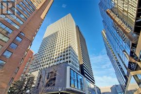 Toronto (Bay Street Corridor) condo for rent - A tall building with a glass facade stands between two other buildings.