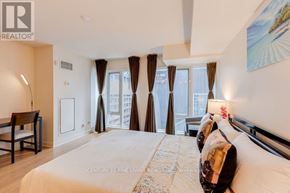 Toronto (Church-Yonge Corridor) condo for rent - A bedroom with a large bed and a view of the city through the windows.