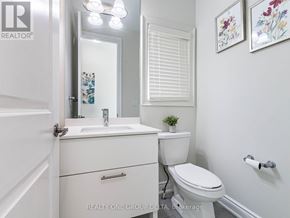 Brampton (Bram West) apartment for rent - A white bathroom with a toilet, sink, and mirror.