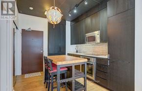 Toronto (Waterfront Communities) condo for rent - A kitchen with a table and chairs in front of a wooden cabinet.