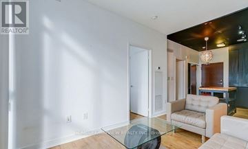 Toronto (Waterfront Communities) condo for rent - A living room with a glass table and white couch.