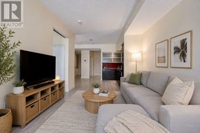 Toronto (Waterfront Communities) condo for rent - A living room with a grey couch, a wooden coffee table, and a flat screen TV.
