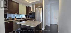 Toronto (Bay Street Corridor) condo for rent - A modern kitchen with dark brown cabinets and a marble countertop.