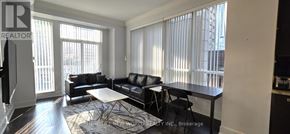 Toronto (Bay Street Corridor) condo for rent - A living room with a black couch and a white coffee table.
