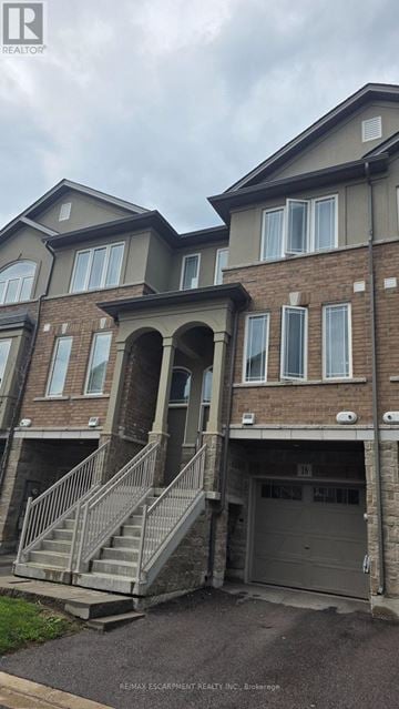 Hamilton townhouse for rent - A building with a grey roof and a garage door.