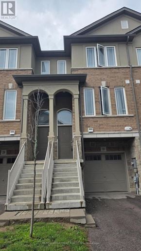 Hamilton townhouse for rent - A house with a grey front door and a tree in front of it.