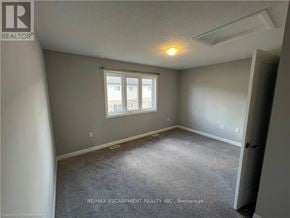Hamilton townhouse for rent - A room with a window and a carpeted floor.