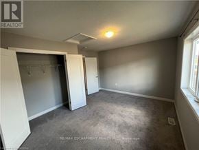 Hamilton townhouse for rent - A room with a carpeted floor and a ceiling fan.