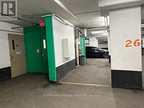 Toronto (Willowdale East) condo for rent - A parking garage with a green door and a black car parked in the background.