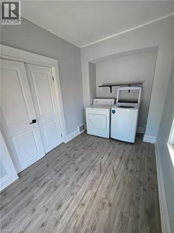 Hamilton apartment for rent - A kitchen area with a fridge, dishwasher and a washing machine.