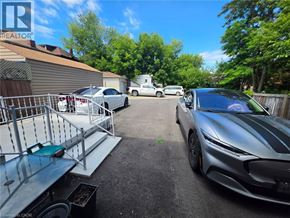 Hamilton apartment for rent - A silver sports car is parked in a driveway with a metal grill and a green bench.